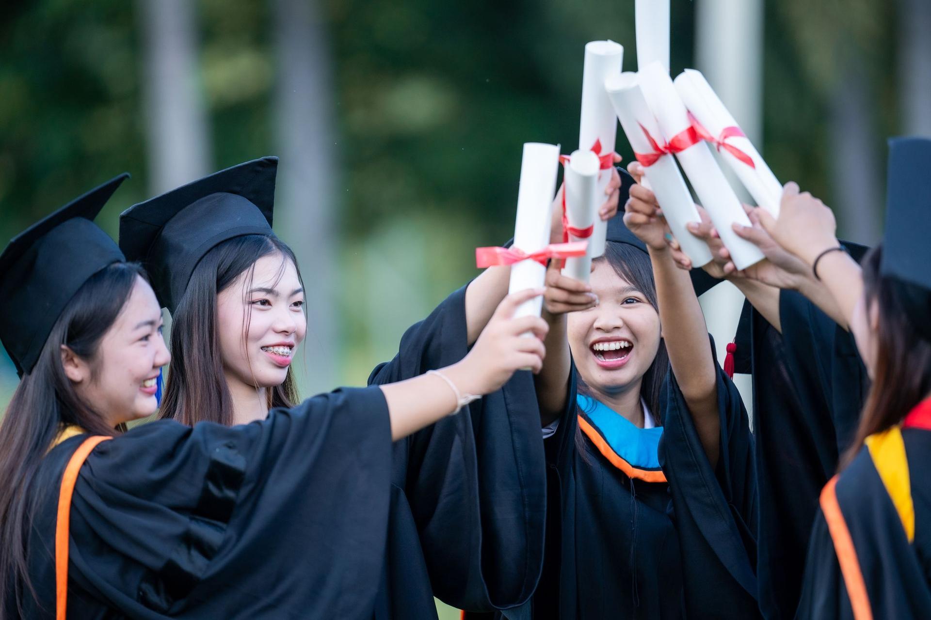 Graduates proudly displaying their diplomas in celebration of their academic achievements.