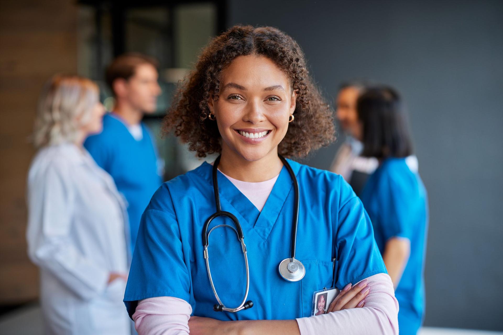 A nurse wearing scrubs addresses a group of people, exemplifying her role in healthcare and community engagement