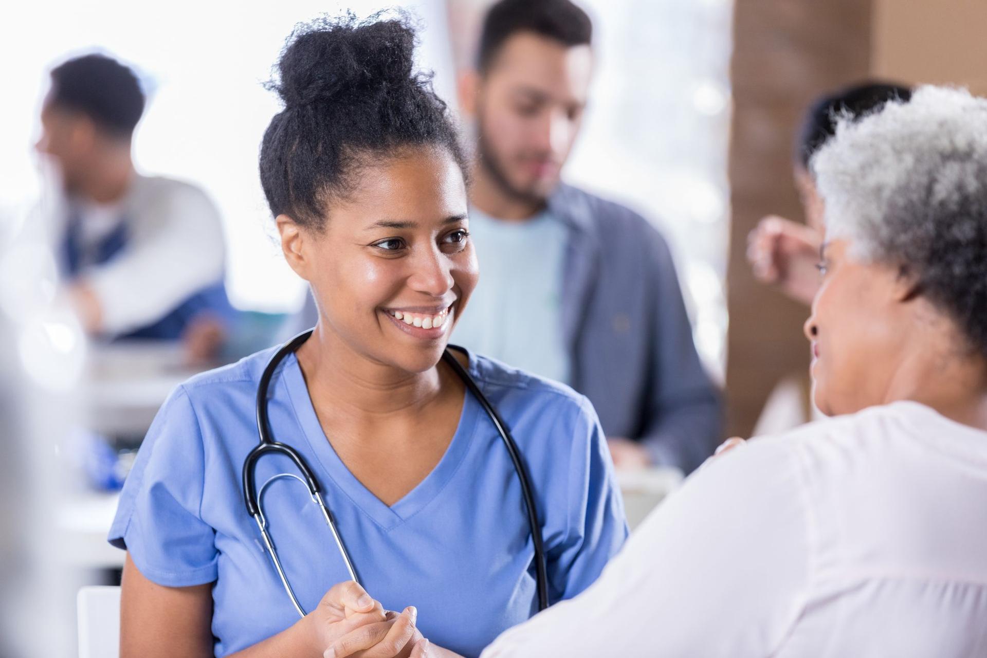 A nurse engages in discussion with a woman, possibly a patient, highlighting the importance of healthcare dialogue.