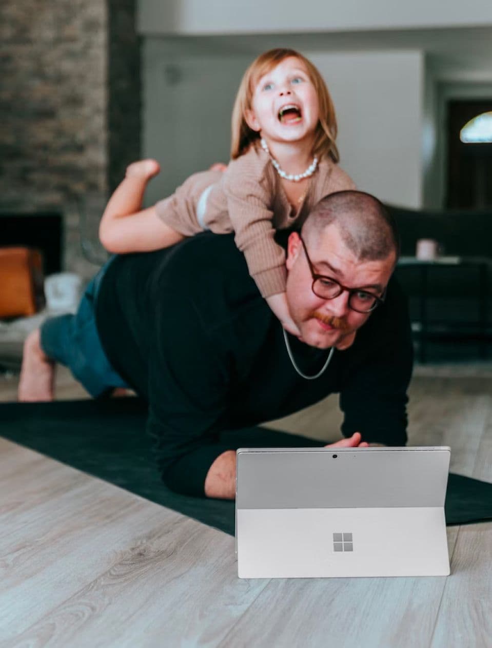 A man playing with a child on his back.