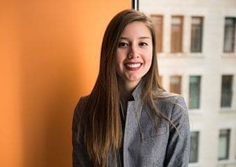 Brand manager in front of a building window smiling