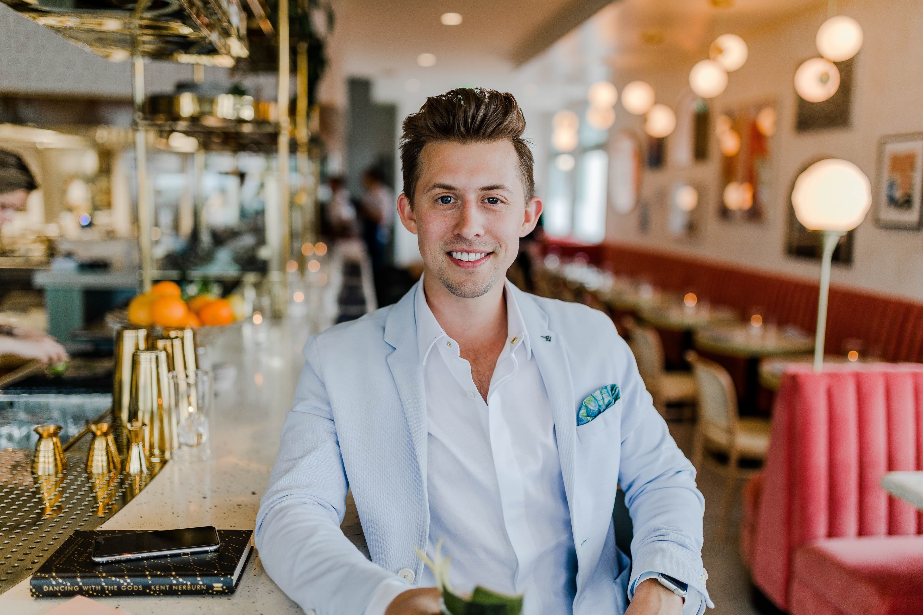 A man wearing a suit seated at a bar