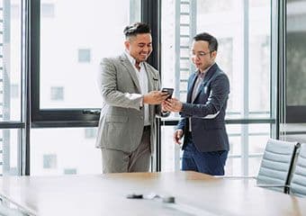 Two bankers interacting in front of a window