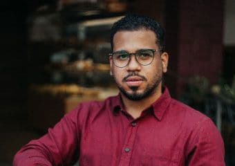 An operations manager wearing glasses and a bright colored shirt