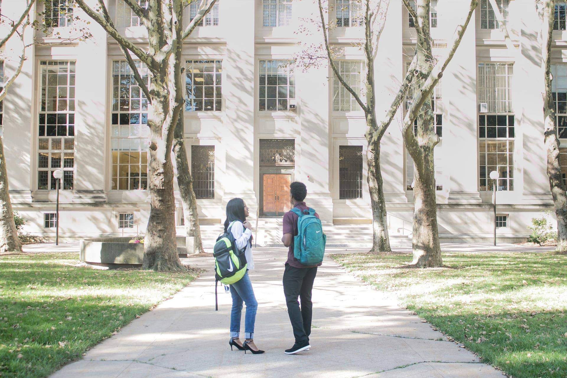 Two students standing in front of a college campus.