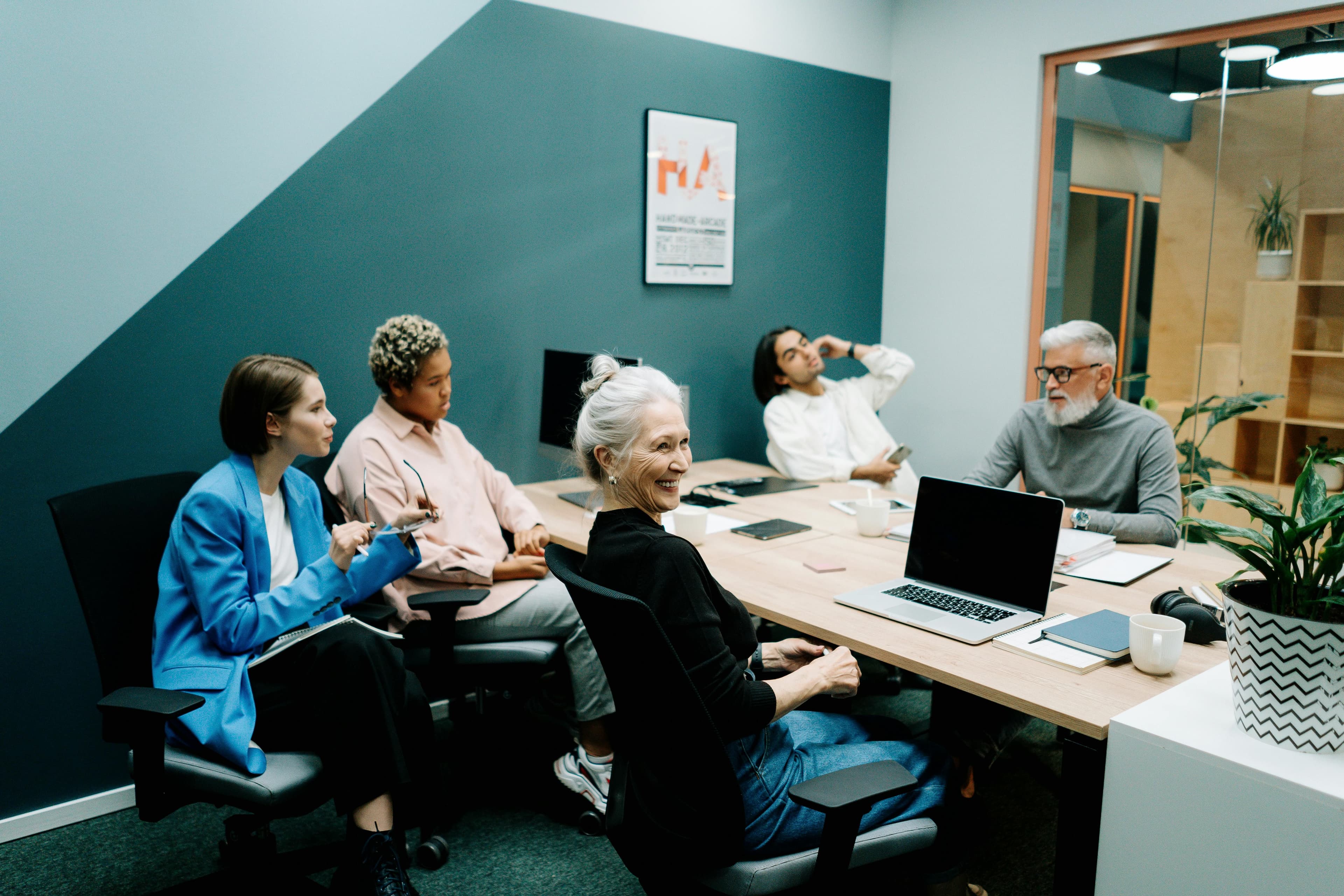 Five people having a meeting in a modern office.