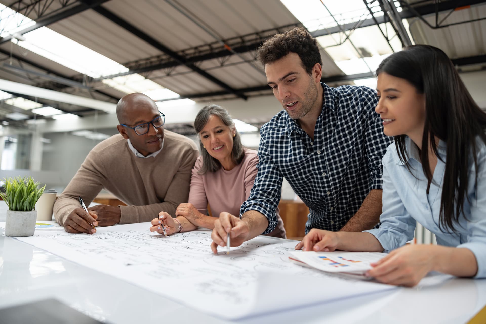 Several individuals focused on a document placed on a table, discussing its contents.